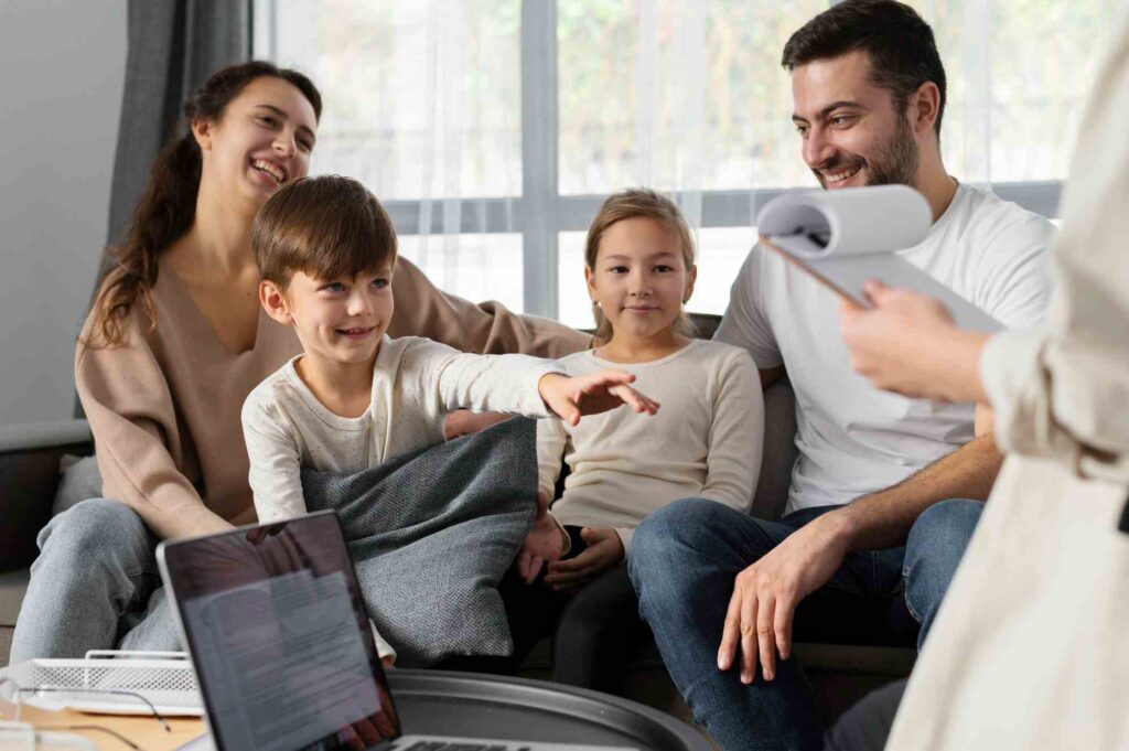 Happy family on couch with medical professional in foreground.