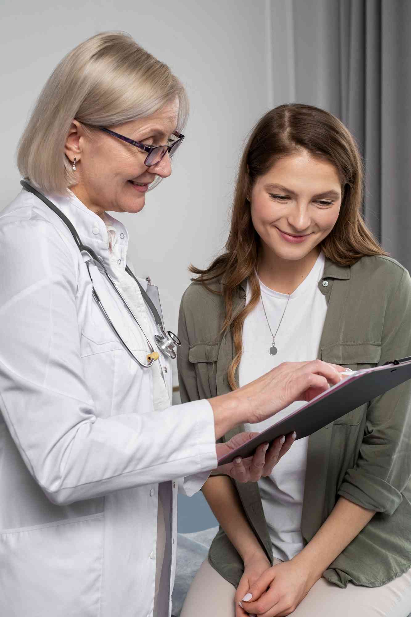 Doctor looking over clipboard with patient